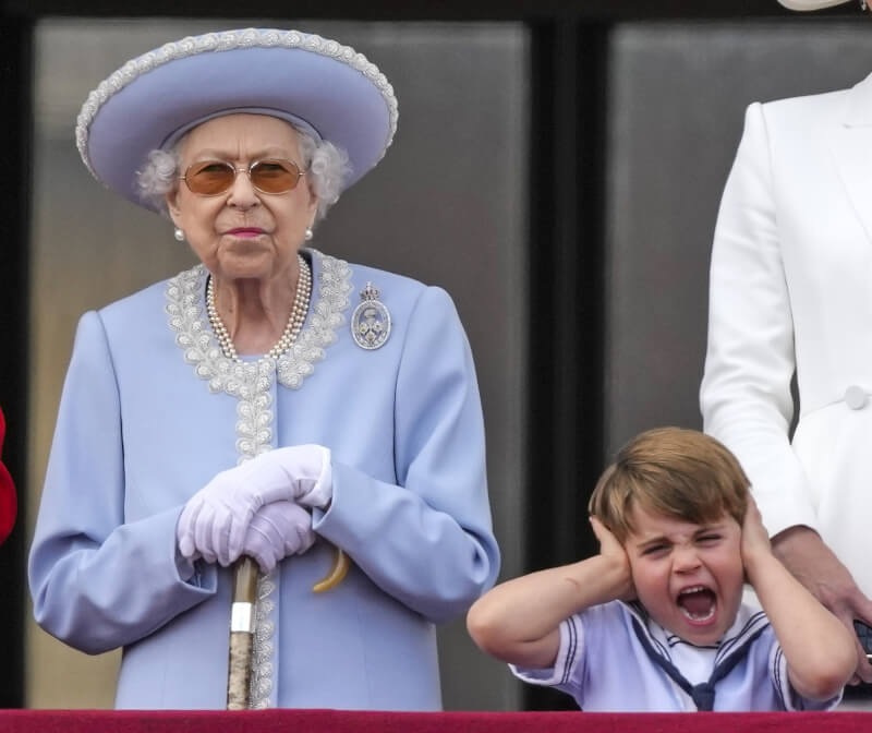 4歲的路易王子（右）在露台觀看軍機飛行表演時，因為空中傳來的聲音嘈雜，雙手捂耳大叫，搶盡鋒頭。左為英國伊麗莎白二世女王。（美聯社）