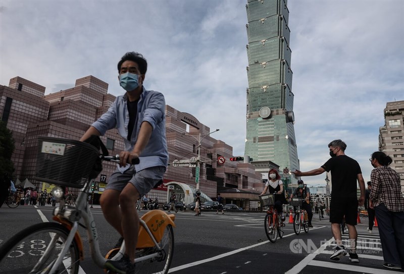 圖為5日傍晚台北市信義區民眾戴口罩騎公共自行車過馬路。（中央社檔案照片）