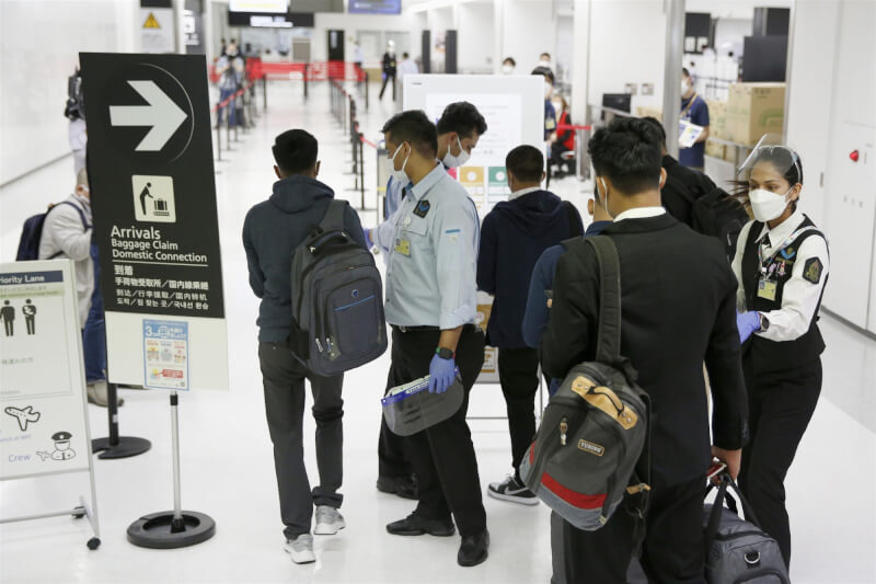日本7日公布防疫指引，要求外國觀光客須戴口罩及投保民間醫療保險。圖為旅客1日在成田機場排隊接受查驗。（共同社）