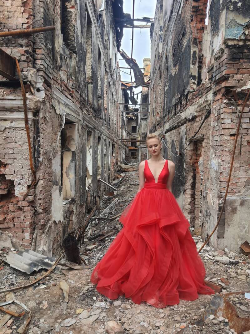 加拿大多倫多的埃皮舍瓦在推特分享一張她16歲侄女瓦萊麗穿著紅色舞會禮服，站在哈爾科夫殘破不堪校舍前的照片。（圖取自twitter.com/EVaPiShe）