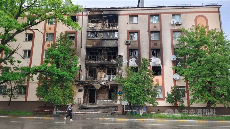 烏克蘭首都基輔市附近的布查鎮，一名路人走過3月間被俄軍砲轟的公寓。（中央社檔案照片）