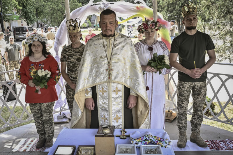 烏克蘭軍隊13日在東部小鎮為兩對情侶舉行婚禮，23歲新娘柳塔（左1）穿迷彩褲和軍靴搭配傳統的烏克蘭紅色繡花上衣出席婚禮。（法新社）