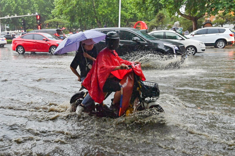 中國華南地區近來豪雨不斷，各地災情頻傳。圖為13日山東省民眾行駛低窪路段。（中新社）
