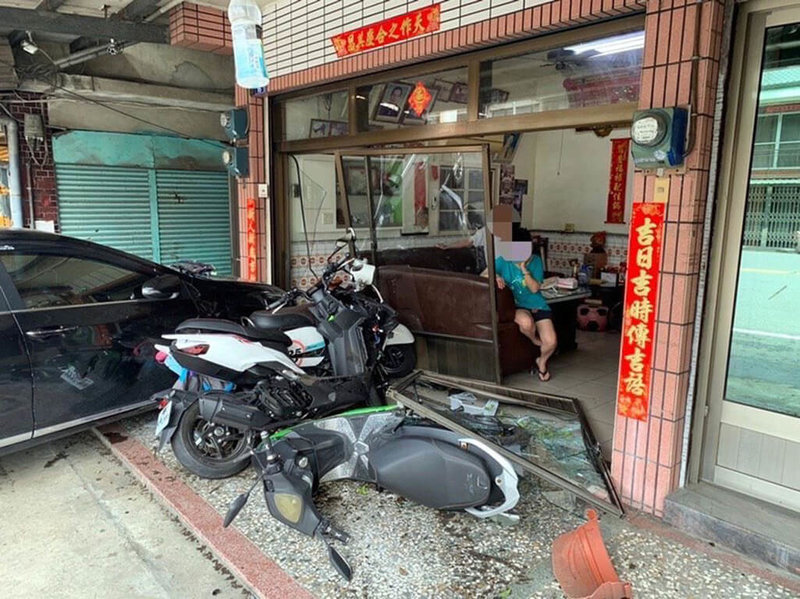 阿里山公路25.5公里處12日發生2部機車交通事故，造成3人輕傷，其中1部機車在騎士與乘客倒地後，在無人騎乘情況下，撞進路旁一處民宅，造成民宅大門損壞，停放在民宅門前1輛自小客車及2部機車也都受損。（警方提供）中央社記者黃國芳傳真  111年6月15日