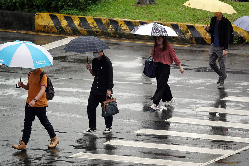 氣象專家吳德榮表示，15日滯留鋒掠過台灣北部，各地有陣雨或雷雨；17日起鋒面逐日北移，但水氣多、各地仍有較大雨勢。圖為民眾在台北南港展覽館附近撐傘過馬路。中央社記者鄭傑文攝  111年6月15日