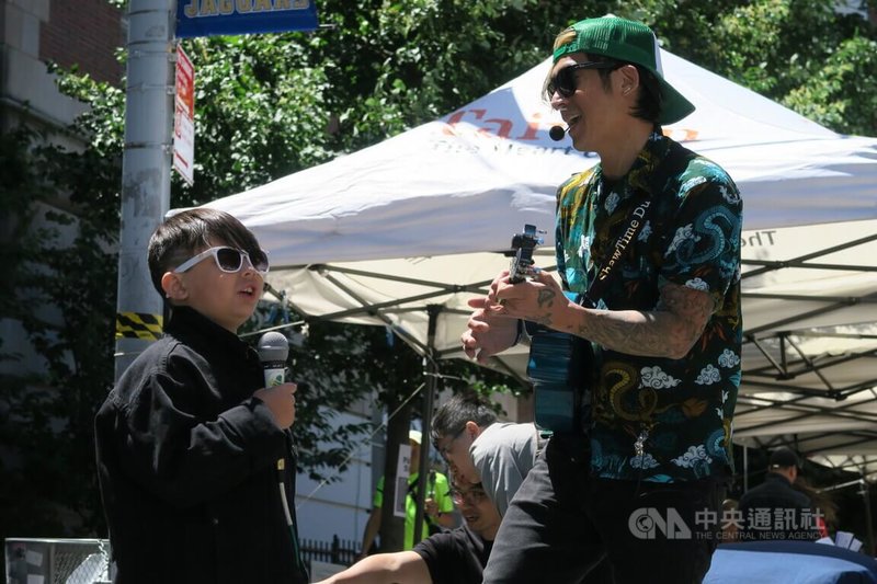 COVID-19疫情趨緩,停辦兩年的台灣文化活動轉型成街坊節TaiwanFest,19日在紐約布魯克林舉辦,從小旅美的歌手蕭文豪(右)與兒子一同演唱。中央社記者尹俊傑紐約攝 111年6月20日