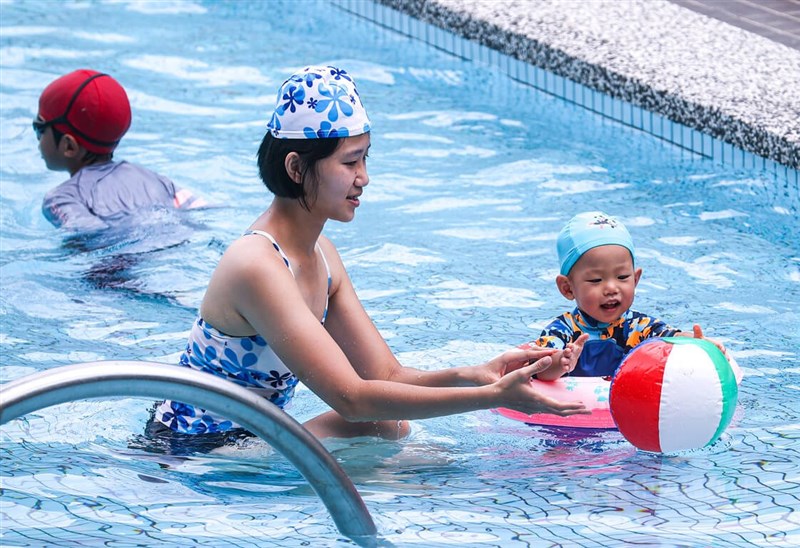 中央氣象局表示21日白天各地高溫均達攝氏32到35度，台北市文山區有民眾帶著孩子來到游泳池戲水消暑，度過炎熱的夏至。中央社記者鄭清元攝 111年6月21日