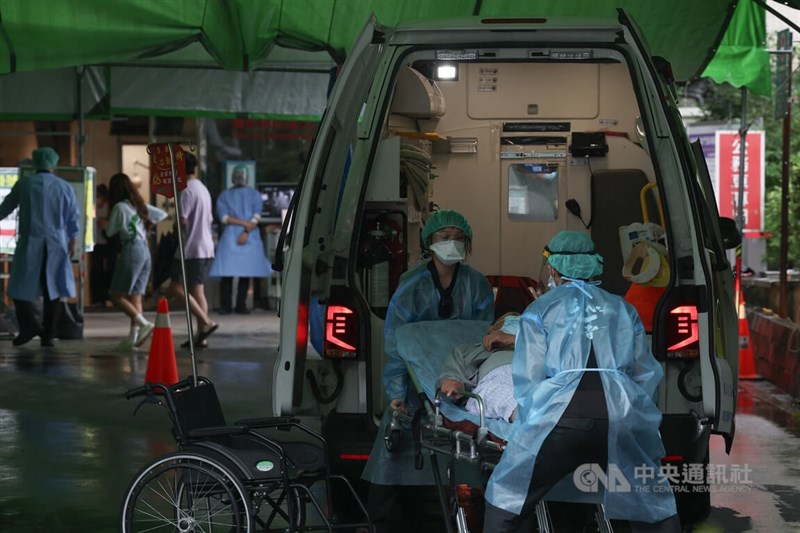 國內21日新增5萬6339例COVID-19本土病例。圖為亞東醫院醫護人員轉移病患進行救治。（中央社檔案照片）
