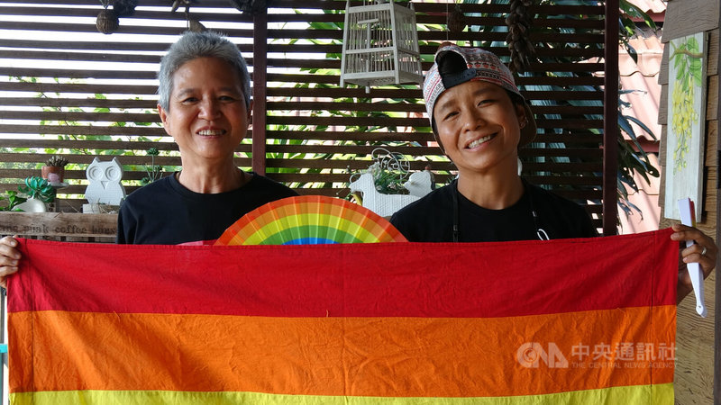彭蘇（左）和蓬佩（右）是泰國第一對向憲法法庭請願禁止同性伴侶登記結婚的法律有違憲疑慮的同志情侶。兩人接受中央社訪問後拿出彩虹旗合照。中央社記者呂欣憓曼谷攝 111年6月23日