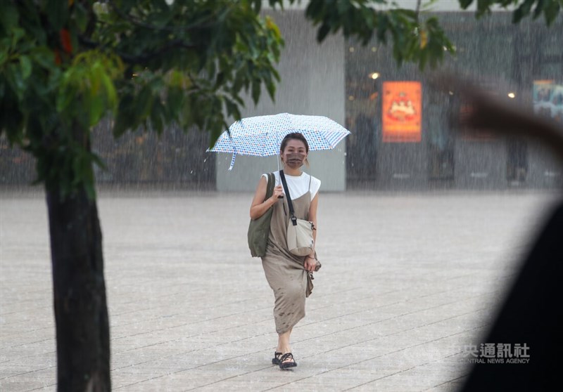受對流雲系發展旺盛影響,中央氣象局24日下午針對14縣市發布大雨特報,其中台北市及新北市也同時發布大雷雨即時訊息。圖為台北市信義區民眾在大雨中拉起裙擺快步走。中央社記者王騰毅攝 111年6月24日