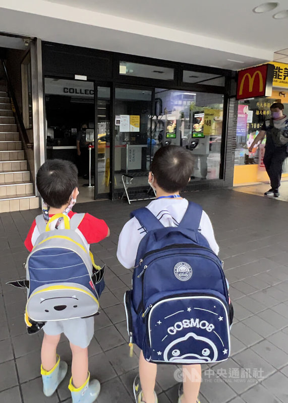 台北市南港區24日下午發生停電狀況,百餘戶商家住戶受影響停電,台電目前持續搶修中。圖為小朋友們站在因停電暫停營業的速食店門前。中央社記者鄭傑文攝 111年6月24日