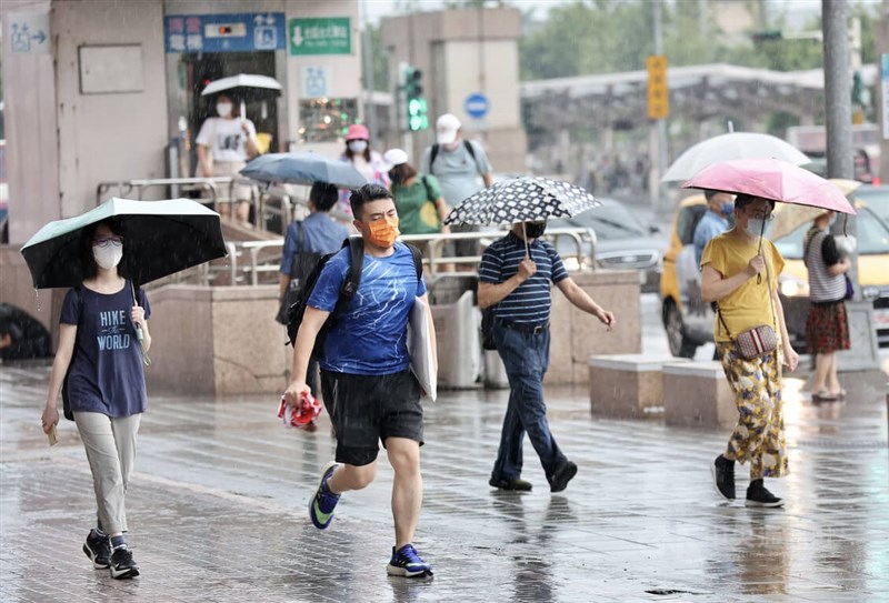 大台北地區25日上午豔陽高照，不過中午過後雲層漸厚，隨即下起不小雨勢，台北車站周邊民眾紛紛撐傘避雨，也有民眾未帶雨具，只得快步走避。中央社記者張皓安攝　111年6月25日