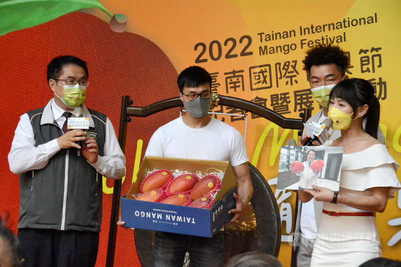 「2022台南國際芒果節」25日在新北板橋大遠百舉行,台南市長黃偉哲(左)北上出席,與前職棒球星郭泓志(後右)同台推廣台南優質芒果,並主持玉文芒果競標活動。中央社記者黃旭昇新北市攝 111年6月25日