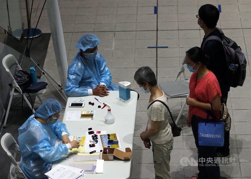 國內26日新增3萬9586例COVID-19本土病例。圖為民眾在台北捷運松山站中型疫苗接種站排隊等待施打疫苗。（中央社檔案照片）