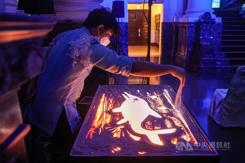 國立台灣博物館推出「水怪—水棲爬行動物化石展」,27日舉行開幕典禮,典禮中邀請沙畫藝術家演出,以細膩沙畫詮釋水棲爬行動物的演化歷史。中央社記者鄭清元攝 111年6月27日