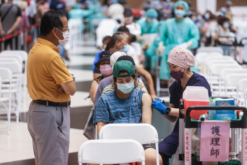 圖為6月間民眾在親友陪同下前往台北車站疫苗接種站施打疫苗。（中央社檔案照片）