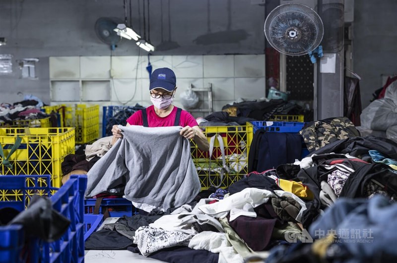 新北市五股山區的回收廠工作人員正將舊衣物逐一細分類。中央社記者趙世勳攝 111年6月27日