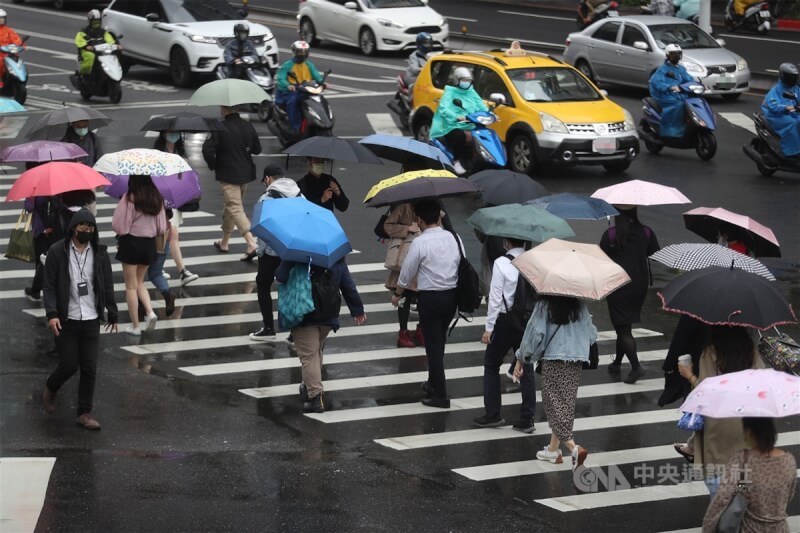 氣象局統計，今年梅雨季因鋒面影響，5月創下全台日照時數同期最少紀錄。圖為台北市民眾撐傘遮擋雨勢。（中央社檔案照片）