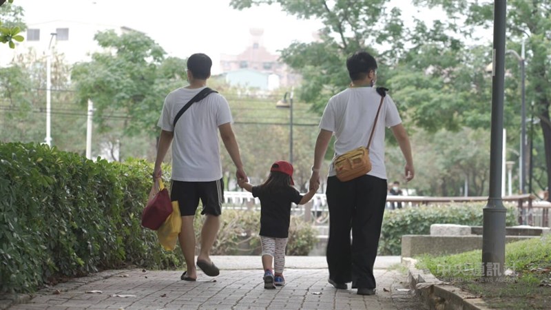 台灣同志伴侶圍圍（右）、喵喵（左）牽著收養女兒肉肉，散步回家。中央社記者張智彥高雄攝 111年6月28日