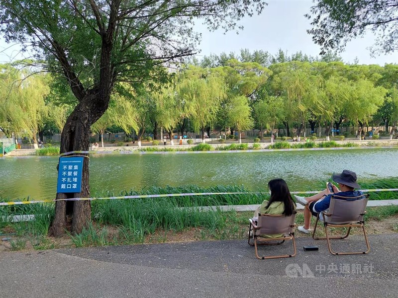 北京市從4月30日到6月初都禁止餐飲內用與人群聚集。不過,即使在緊張的防疫要求下,民眾仍盡量保持自己的休閒生活。圖為北京亮馬河邊休息的民眾。中央社記者張淑伶北京攝 111年6月29日