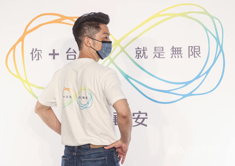 國民黨台北市長參選人蔣萬安30日上午公布競選標語及LOGO,親自穿上白色競選T恤,轉身展示背後的競選識別設計。中央社記者鄭清元攝 111年6月30日