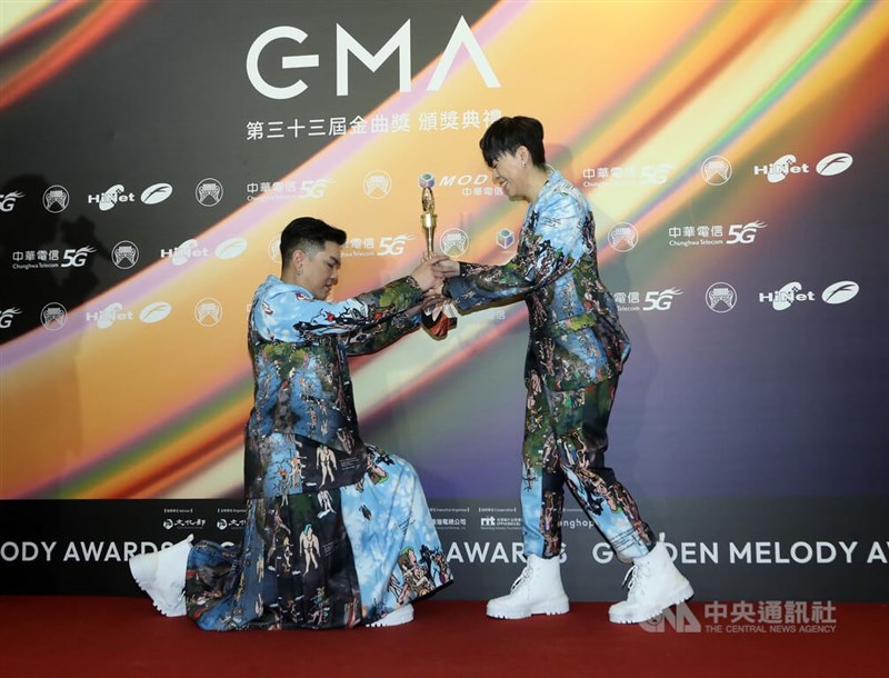 歌手江惠儀(右)拿下個人第2座金曲最佳台語女歌手獎,她的製作人男友三秒(左)在後台被現場媒體起鬨,拿起獎座單膝下跪模擬求婚場景。中央社攝影記者王騰毅攝 111年7月2日