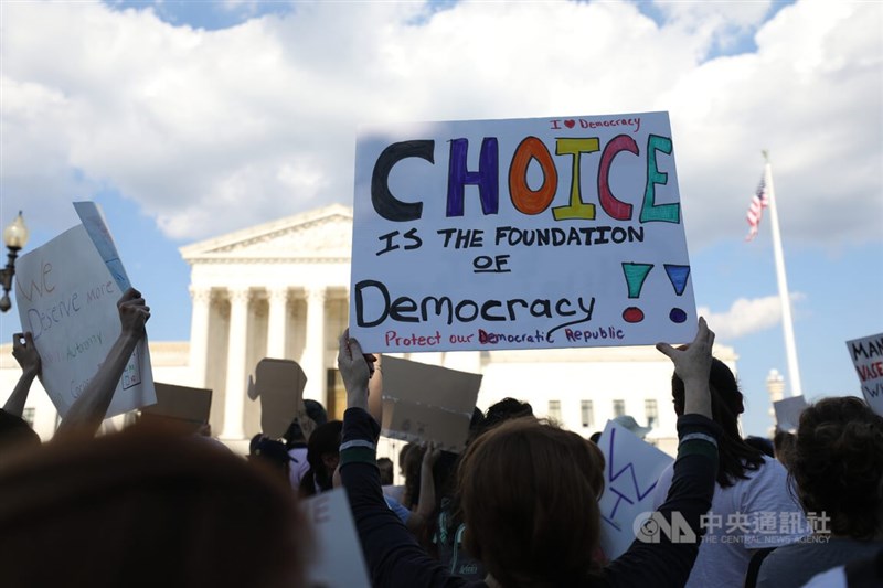 圖為挺墮胎權婦女6月25日在美國最高法院外高舉「選擇權是民主根基」示威牌。（中央社檔案照片）