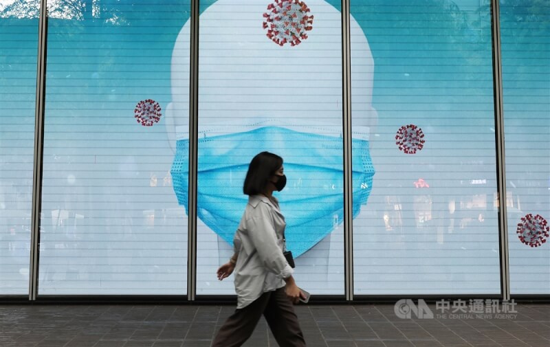 圖為民眾在台北市信義區經過廣告燈箱。（中央社檔案照片）
