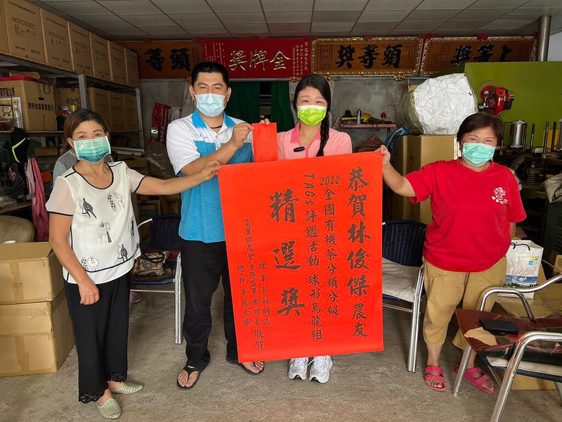 全國有機茶分類分級TAGs評鑑,花蓮縣富里、玉里、瑞穗均有斬獲,共囊括3銀4銅,富里鄉茶農林俊傑(左2)奪得1銀3銅佳績,富里鄉農會總幹事張素華(右2)前往貼紅榜祝賀。(林俊傑提供)中央社記者李先鳳傳真 111年7月3日