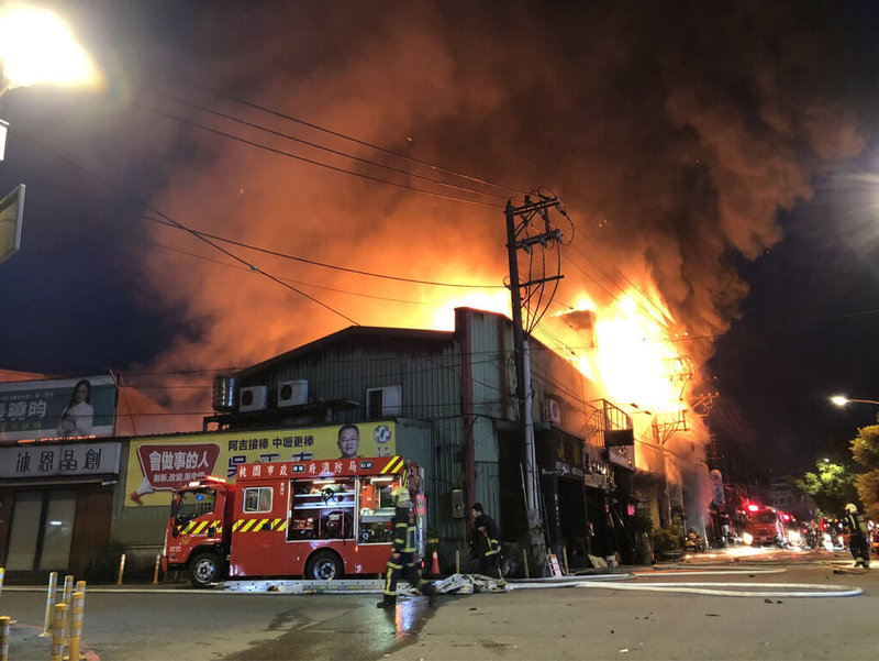 桃園市中壢區培英路一處鐵皮連棟的兩層樓殯葬服務業公司住宅4日凌晨發生火警,猛烈火勢燒毀6間從事殯葬業的禮儀公司,且不斷冒出濃煙,消防人員抵達現場後,立即拉水線進行搶救。(讀者提供)中央社記者吳睿騏桃園傳真 111年7月4日