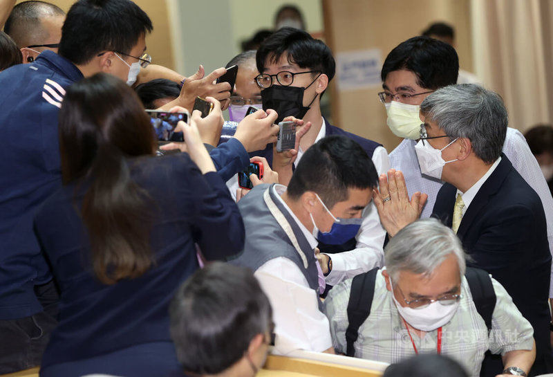 中央研究院第34次院士會議4日舉行開幕式,前副總統陳建仁(右)出席時,被媒體包圍詢問是否會參與年底選戰,陳建仁雙手合十,僅以招牌微笑回應「謝謝、平安」。中央社記者鄭傑文攝 111年7月4日