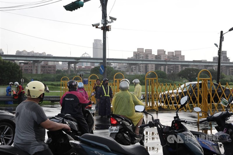 新北市4日下午雷陣雨侵襲,造成二重疏洪道積淹水,為顧及民眾安全,新北市政府派員進行疏洪十路以北區域路段越堤道管制,許多機車騎士紛紛改道。中央社記者趙世勳攝 111年7月4日