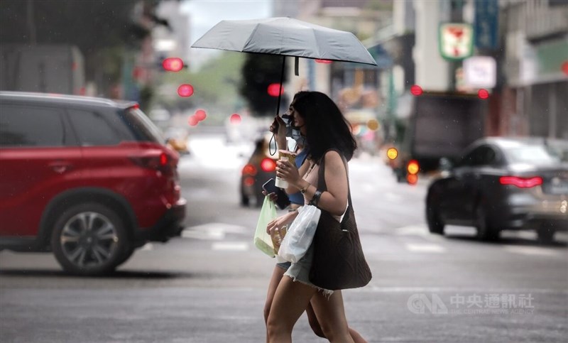 中央氣象局4日下午發布大雨特報，西南風影響及午後熱對流發展旺盛，北北基、中南部及宜花等15縣市可能有局部大雨發生。圖為台北市中正區街頭民眾撐傘遮雨。中央社記者王飛華攝 111年7月4日