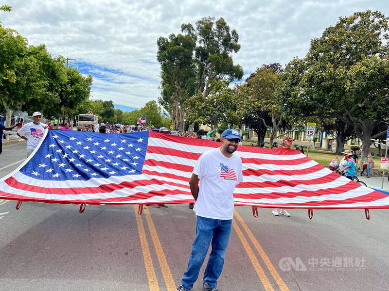 加州聖荷西舉行7月4日國慶遊行，民眾張開大幅美國國旗，期許包容。中央社記者周世惠聖荷西攝  111年7月5日