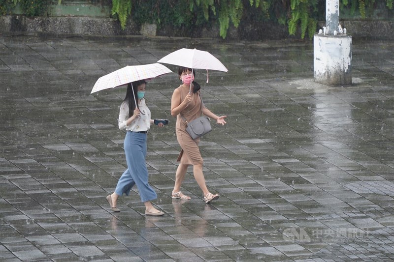 台北市大同区民众撑伞遮雨。（中央社档案照片）