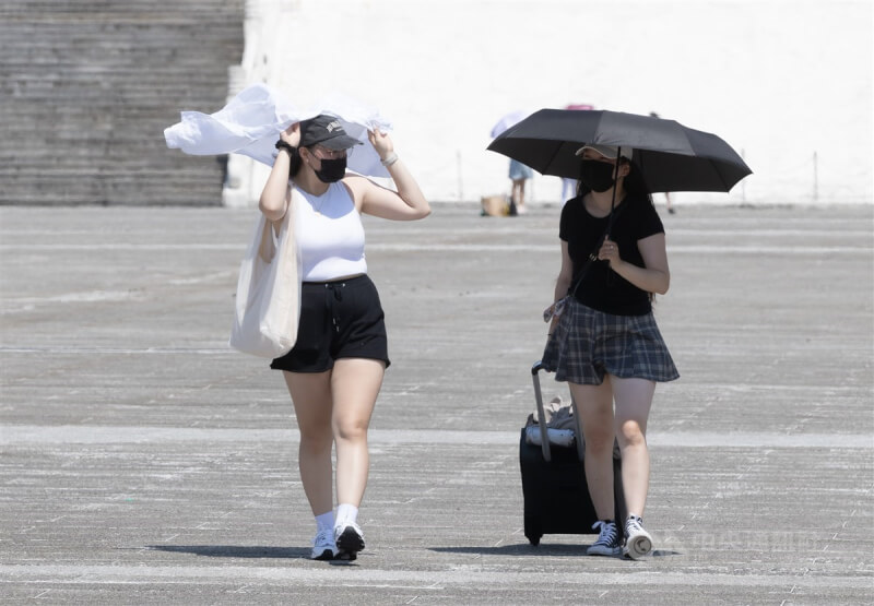中央氣象局6日發布高溫資訊，雙北、新竹、花東需防攝氏36度以上高溫。圖為中正紀念堂園區內民眾用衣服、撐傘遮陽。（中央社檔案照片）