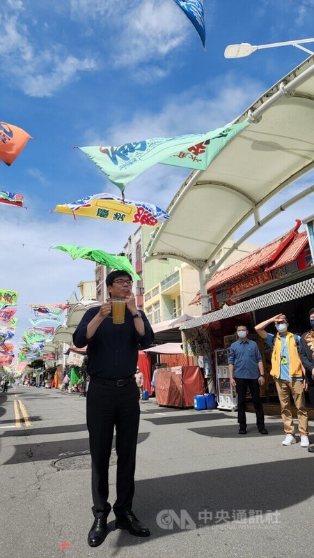 高雄市長陳其邁(前)6日前往旗津宣傳週末起將開跑的黑沙玩藝節跟啤酒嘉年華,並向現場媒體展示嘴上的啤酒泡沫。中央社記者洪學廣攝 111年7月6日