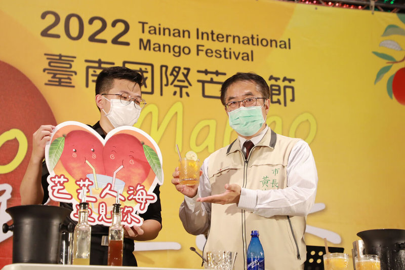 台南市農業局8日晚間在緊鄰大東夜市的農委會水土保持局台南分局前停車場,舉辦全國首創的夜間農產市集,市長黃偉哲(右)也到場發放400份促銷券,行銷台南優質芒果等農產品。(台南市政府提供)中央社記者張榮祥傳真 111年7月8日
