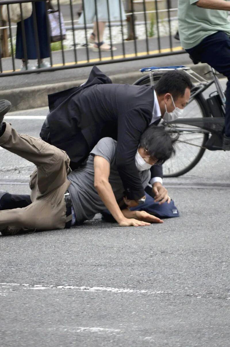 日本前首相安倍晉三遭槍擊身亡，日本警察廳25日公布維安工作調查結果。圖為事發現場嫌犯山上徹也（灰衣者）被撲倒逮捕。（Yomiuri Shimbun via 美聯社）