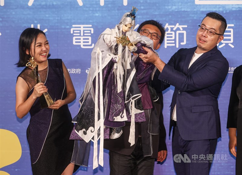 2022台北電影節9日晚間在中山堂舉行頒獎典禮,布袋戲電影「素還真」拿下最佳動畫片等獎項,劇組成員特別讓當家男主角素還真親自捧獎盃慶祝。中央社記者鄭清元攝 111年7月9日
