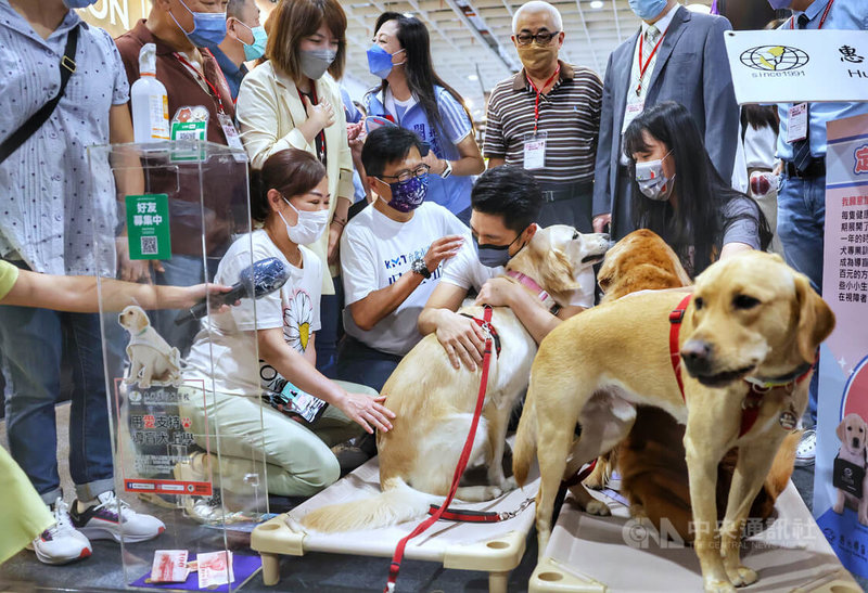 國民黨台北市長參選人蔣萬安（前右2）10日前往南港展覽館參觀台北寵物用品展，並擁抱現場的導盲犬。中央社記者王飛華攝　111年7月10日