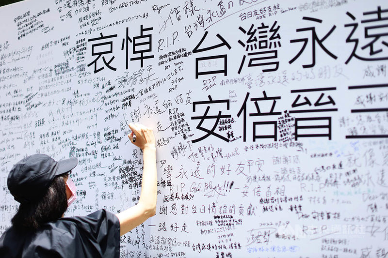 日本前首相安倍晉三8日在奈良遇刺身亡，有民間單位在日本台灣交流協會外設置留言牆，10日中午太陽炎熱，但仍有許多民眾到場簽名悼念。中央社記者游凱翔攝 111年7月10日