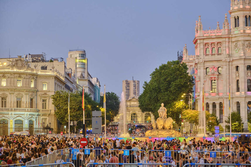 西貝萊斯廣場（Plaza de Cibeles）在天黑後打上彩虹燈光，呼應LGBTI+驕傲遊行主題。民眾在廣場上一面唱歌跳舞，一面等待遊行花車經過。中央社記者胡家綺馬德里攝 111年7月9日