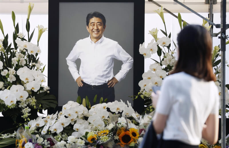 日本內閣會議22日正式決定9月27日在東京的日本武道館舉辦悼念安倍的國喪。圖為11日民眾到增上寺裡獻花向安倍道別。（共同社）