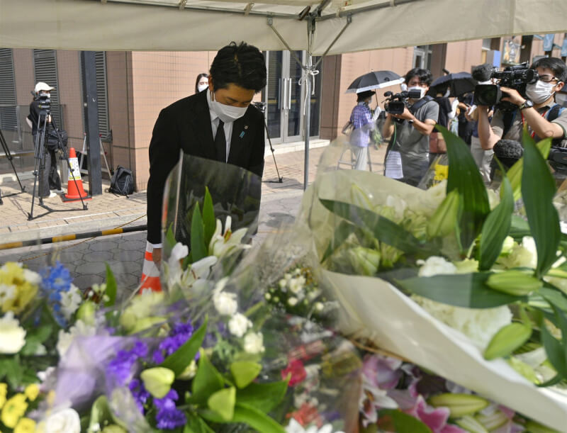 日本參議員佐藤啟（前）順利連任，11日前往安倍晉三遭槍擊現場附近的獻花台默禱。（共同社）