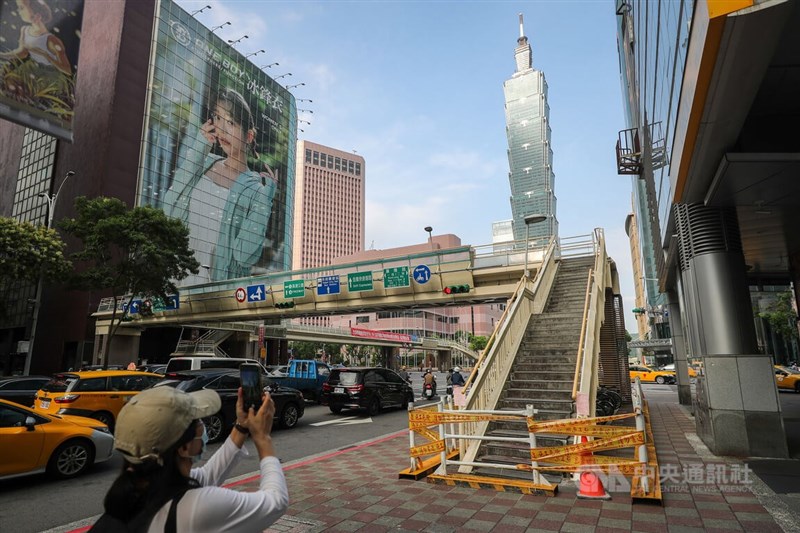 位於台北市信義區信義路與基隆路交叉口的世貿人行天橋將退役,台北市新工處12日上午將天橋封閉,預計15日起利用連續2個週末晚間至週日凌晨分批拆除,路過民眾在天橋下拍照留念。中央社記者裴禛攝 111年7月12日