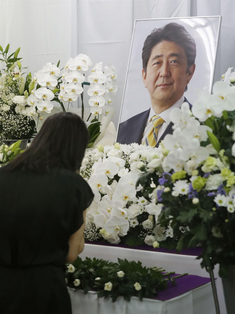 日本政府定9月27日為已故前首相安倍晉三舉行國葬，外交部表示，政府已接獲日方通知。圖為7月12日山口縣下關市民眾獻花向安倍道別。（共同社）