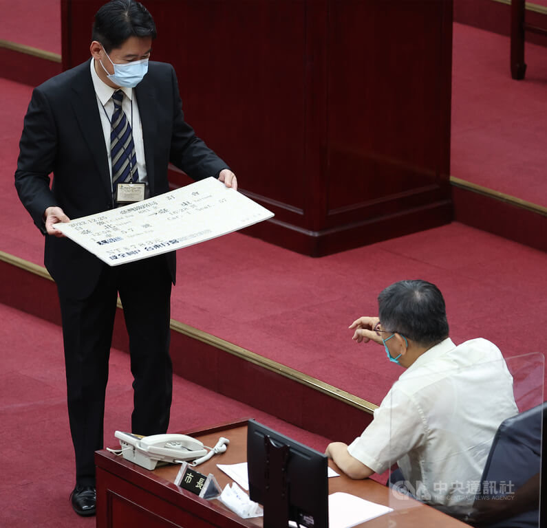 台北市長柯文哲(右)14日是任內最後一次赴北市議會施政報告,議員王世堅送上一張12月25日從台北到台東的大型單程車票看板。中央社記者張新偉攝 111年7月14日