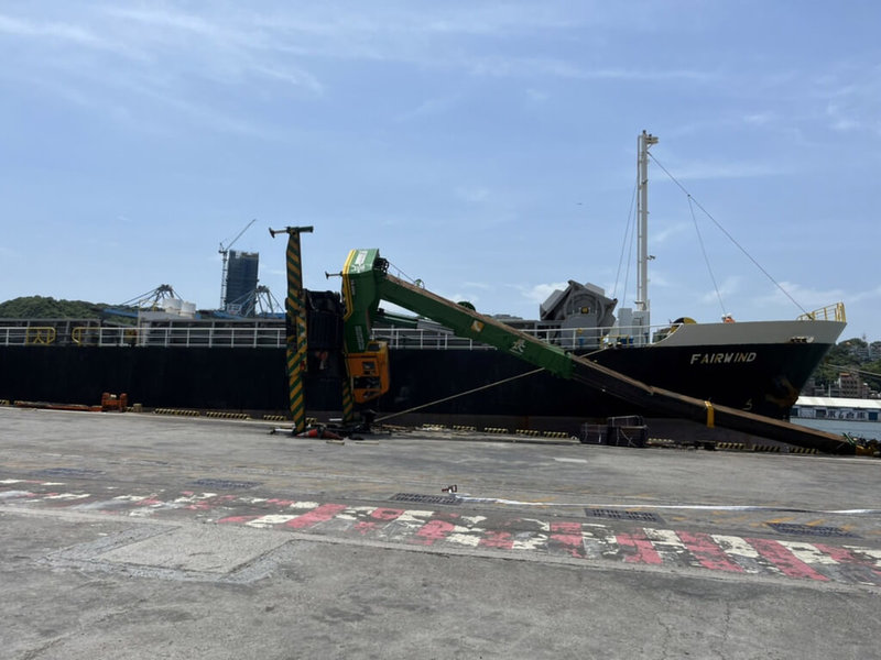 一輛50噸吊車16日在基隆港西16碼頭作業時,突然傾倒,吊臂倒地,造成駕駛膝蓋擦傷。(基隆港務消防隊提供)中央社記者沈如峰基隆傳真 111年7月16日