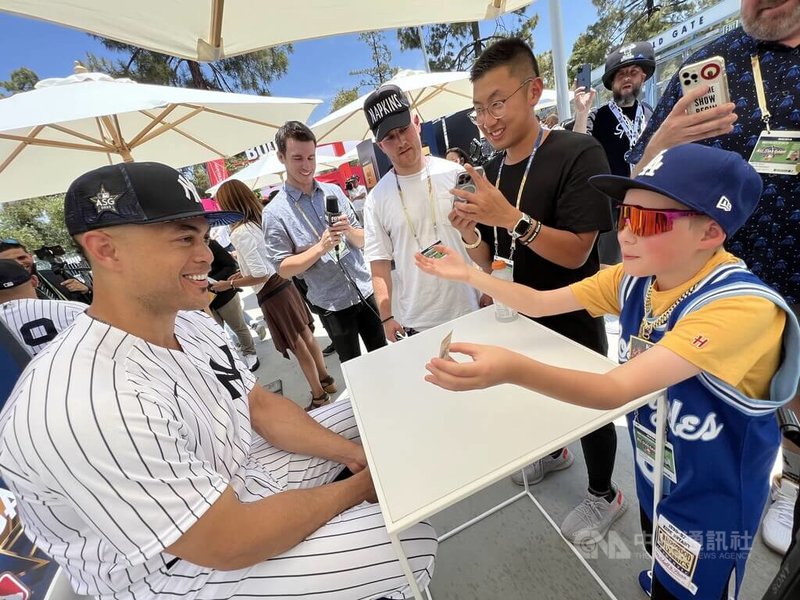 美國職棒紐約洋基隊「怪力男」史丹頓(Giancarlo Stanton)(左) 入選明星賽,美西時間18日在賽前活動與小球迷互動。中央社記者林宏翰洛杉磯攝 111年7月19日